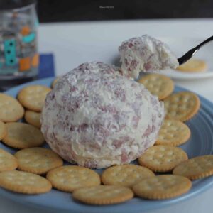 Chipped beef and cream cheese ball appetizer on a party platter with crackers.