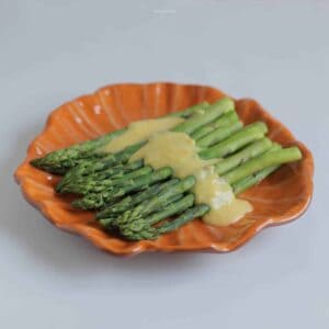 Hollandaise Sauce poured over an asparagus side dish