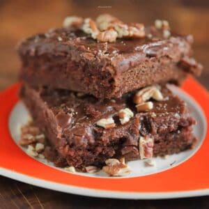 Two brownies stacked on top of each other on an orange plate