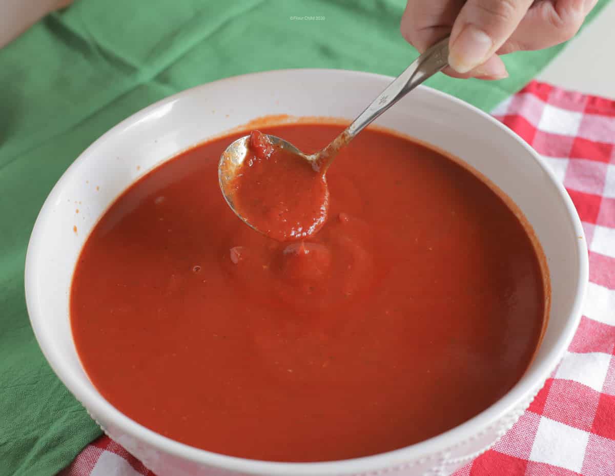 A bowl of red Italian Sunday Sauce in a white bowl