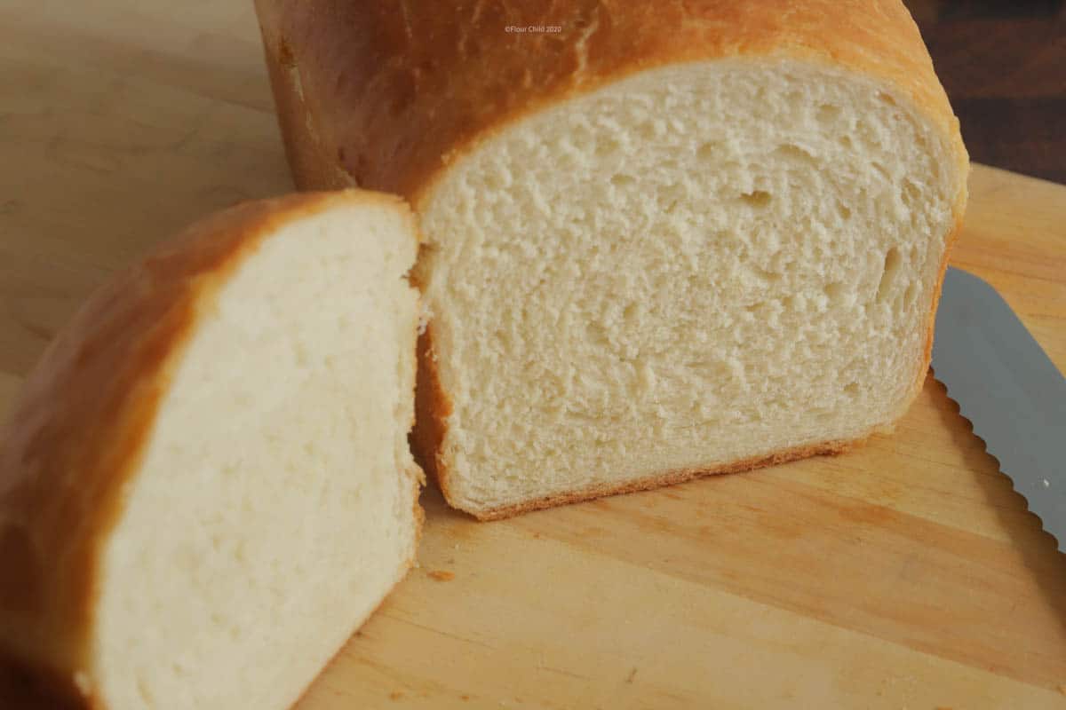 A loaf of homemade whitebread sliced open to show the swirl pattern.