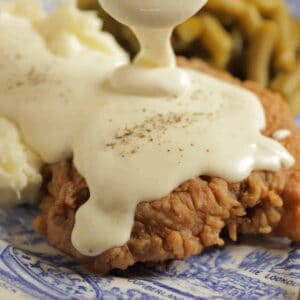 White pepper gravy being poured over a chicken fried steak