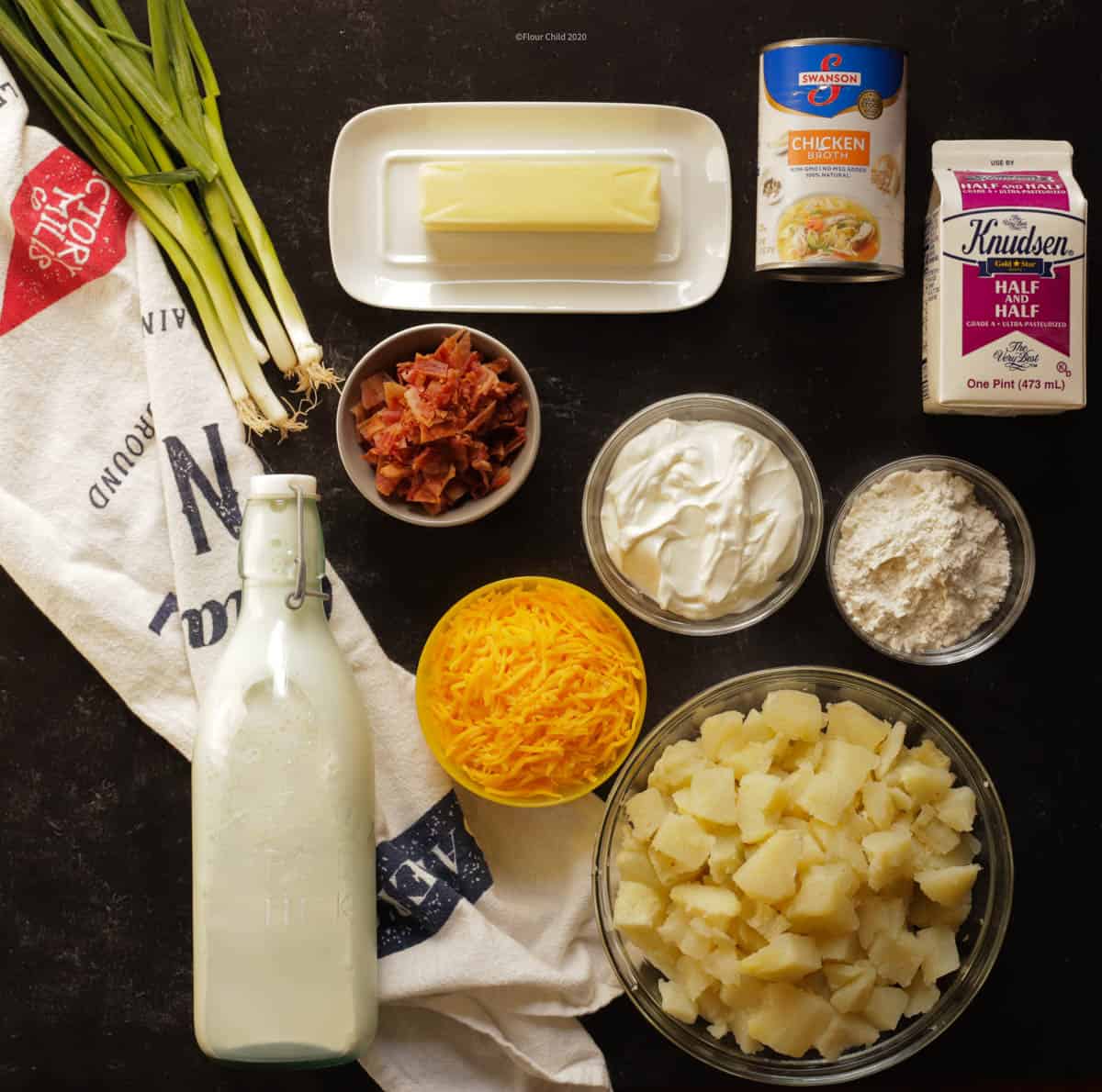 All of the ingredients needed to make baked potato soup are set out on a table