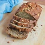 Loaf of banana bread on cutting board, with four slices cut off of it.