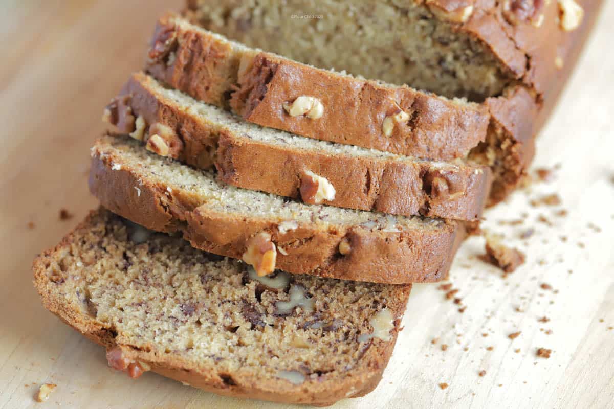 Loaf of banana nut bread on a cutting board with 4 slices sliced off