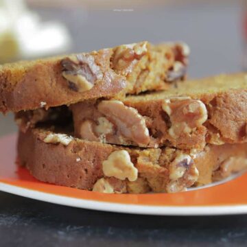 Close up image of 3 slices of pumpkin bread on an orange plate