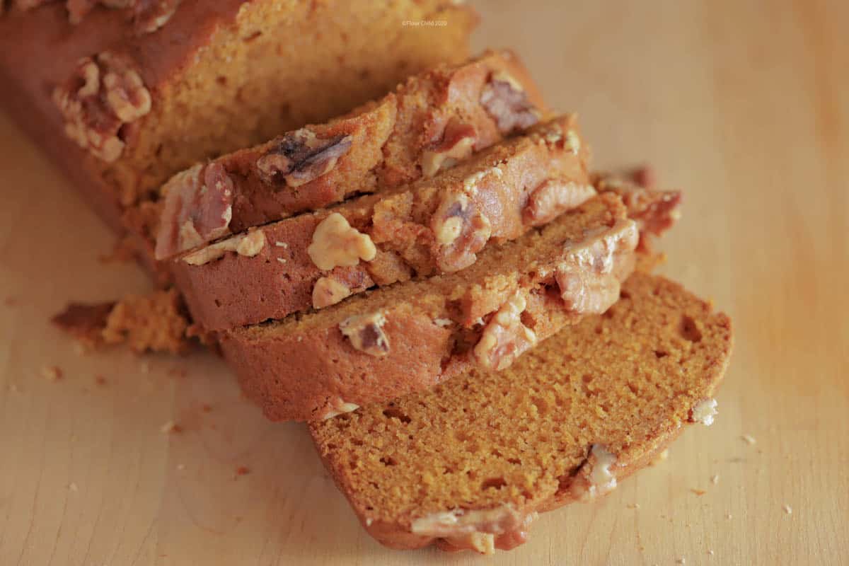 Pumpkin bread sliced into 1 inch slices on a cutting board