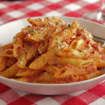 A while bowl with penne pasta in vodka sauce piled high inside