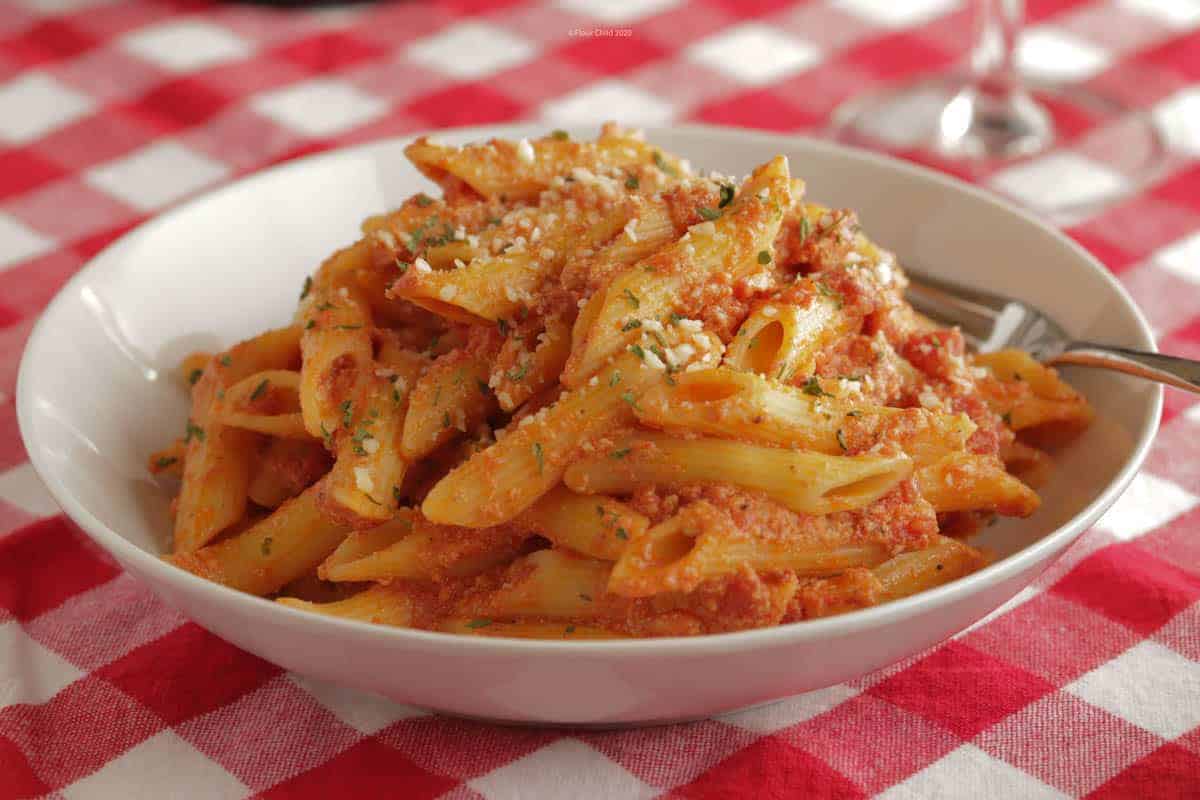 A while bowl with penne pasta in vodka sauce piled high inside