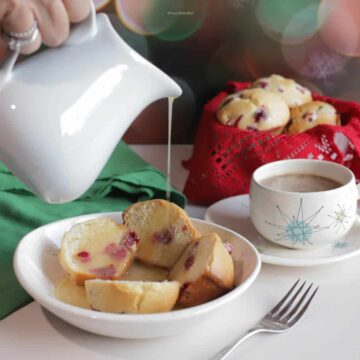 Dish of cranberry muffins with hot butter sauce being poured over the top.