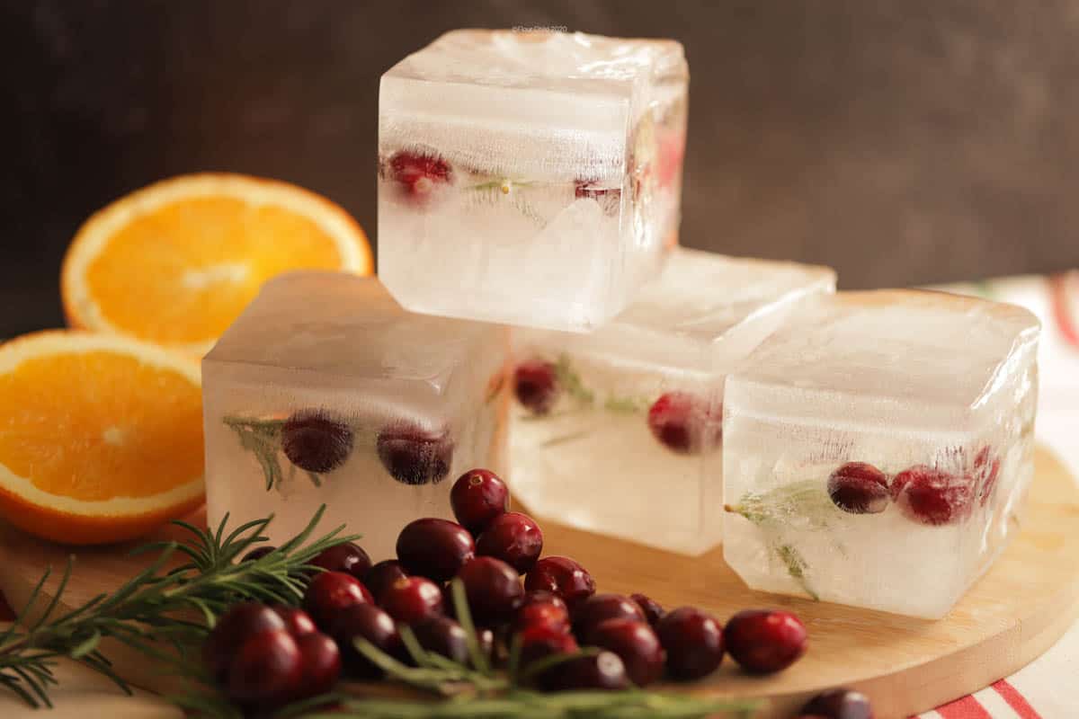 Stack of 4 giant holiday ice cubes with cranberries and rosemary inside