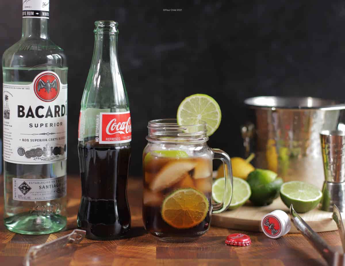 A scene of a Cuba Libre cocktail with a bottle of Coke and Bacardi rum