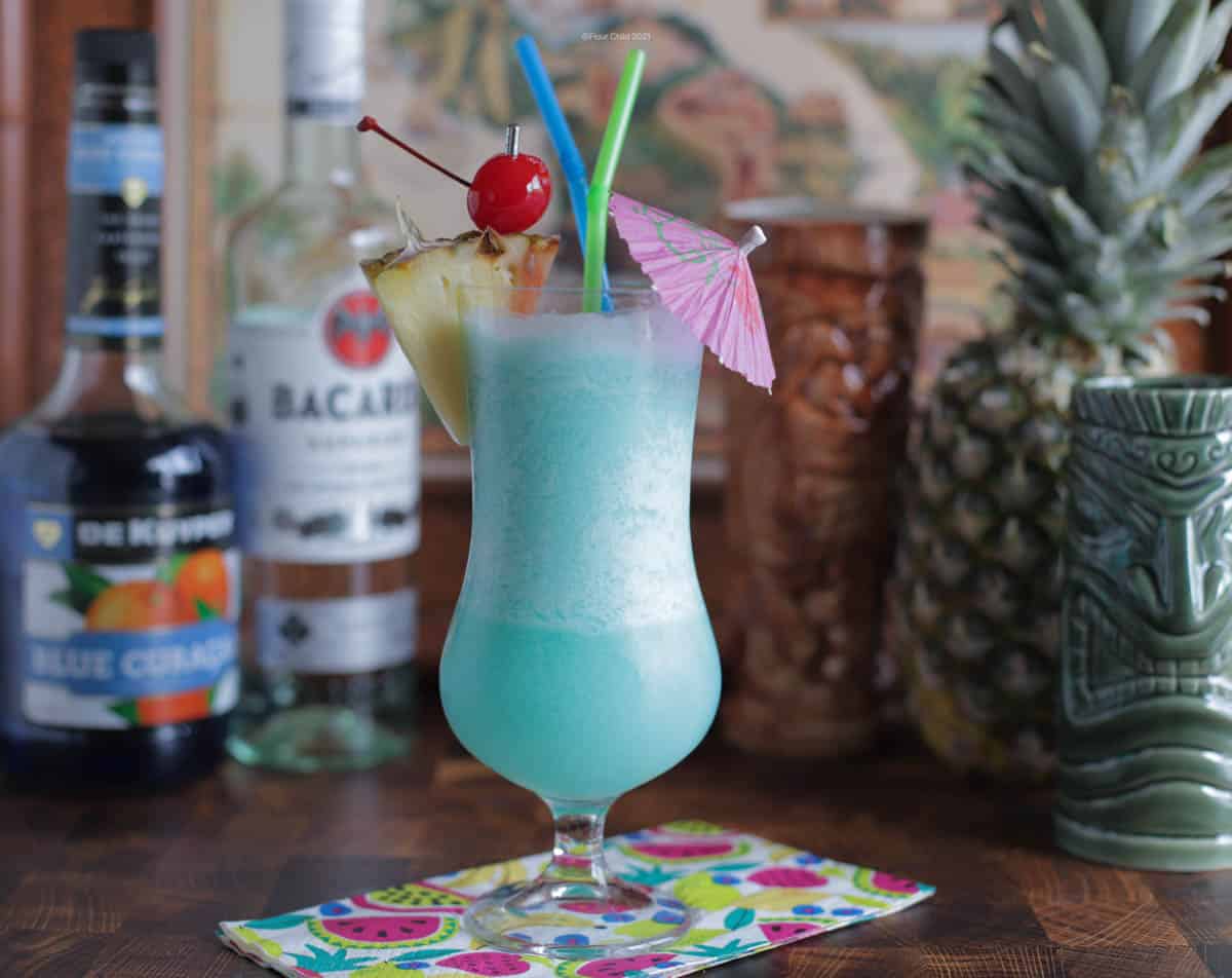 Blue Hawaiian cocktail with spirits and tiki mugs