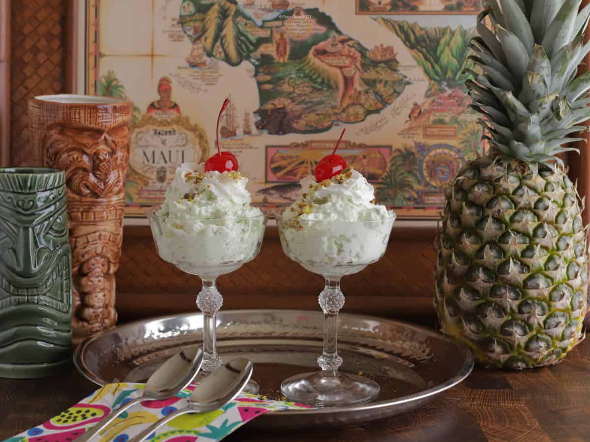 Two servings of Watergate salad in decorative glass cups on a silver tray