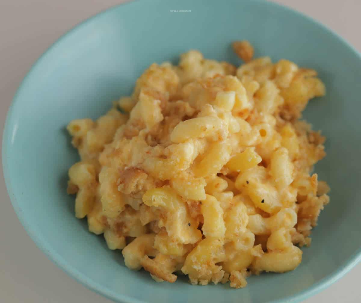 A blue bowl filled with old fashioned macaroni and cheese