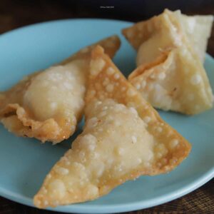 Three pieces of crab rangoon on a blue plate.