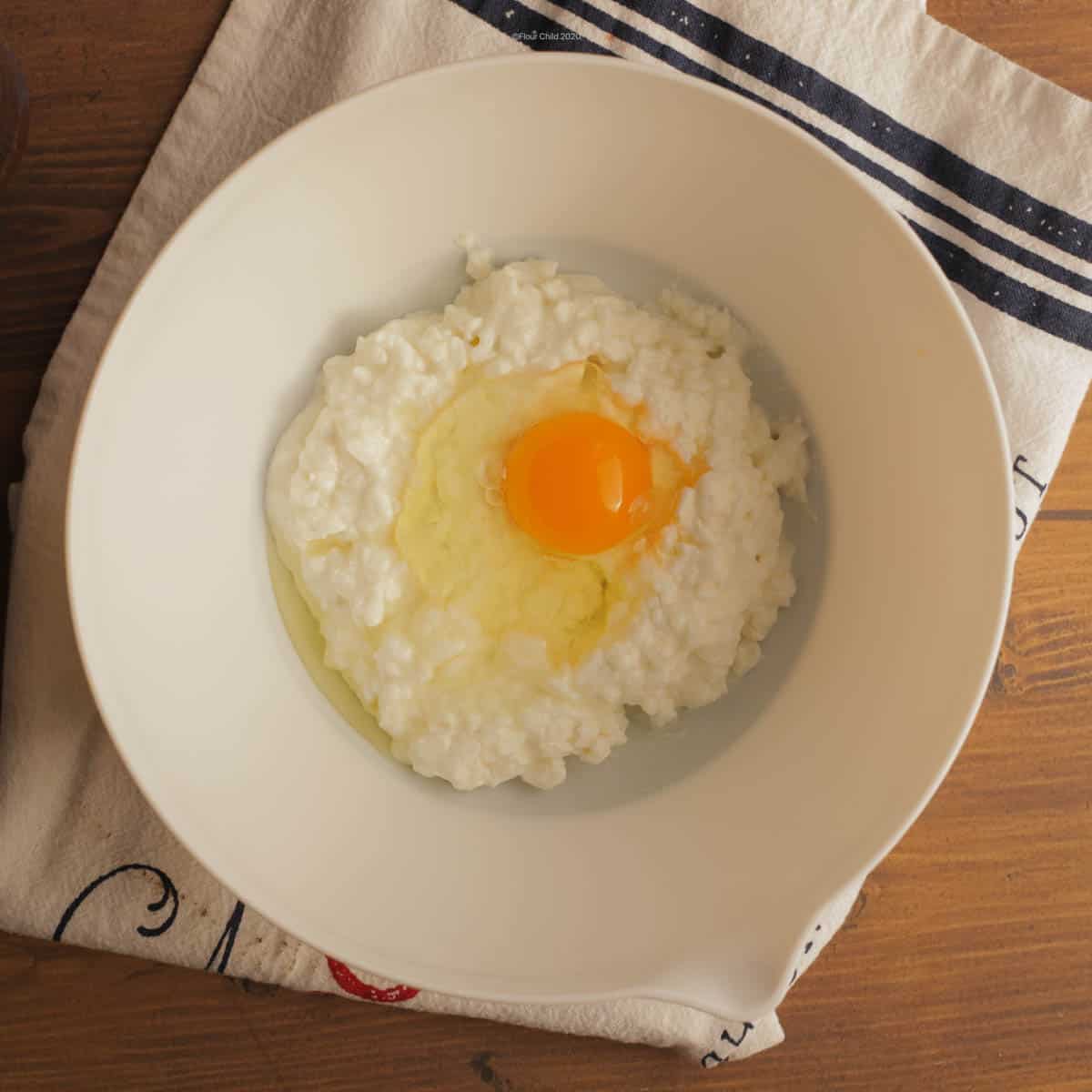 Cottage cheese in mixing bowl with egg added in