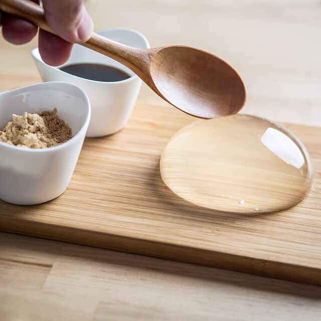 Raindrop cake on a cutting board with a wooden spoon 