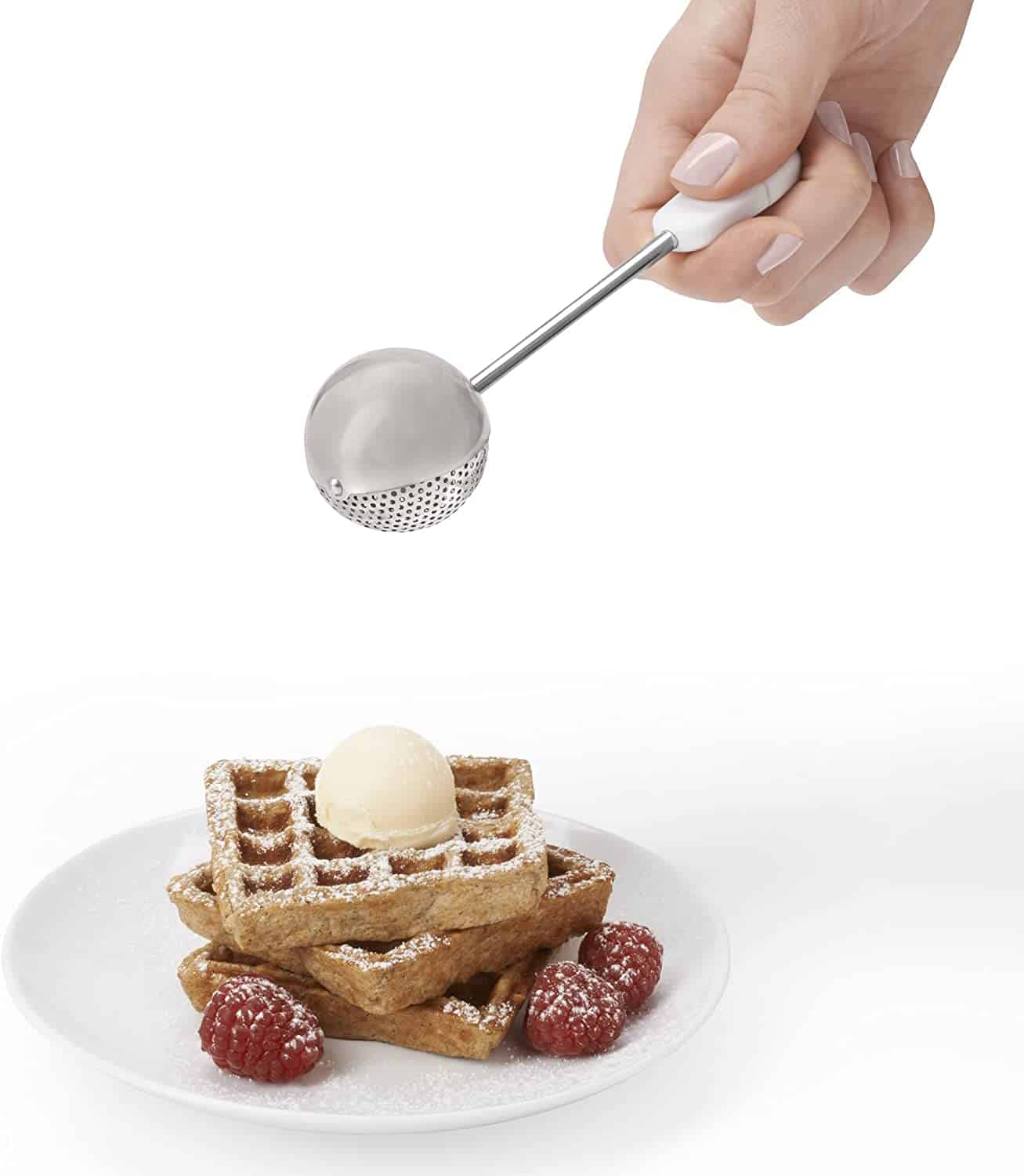 Dusting wand being used to drop powdered sugar over a waffle and berries
