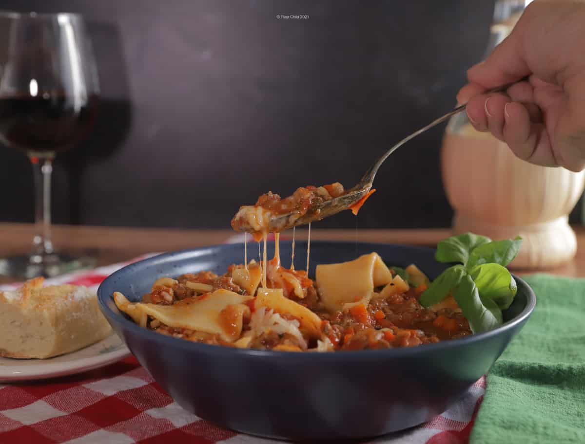 Bowl of lasagna soup with a spoonful being lifted out