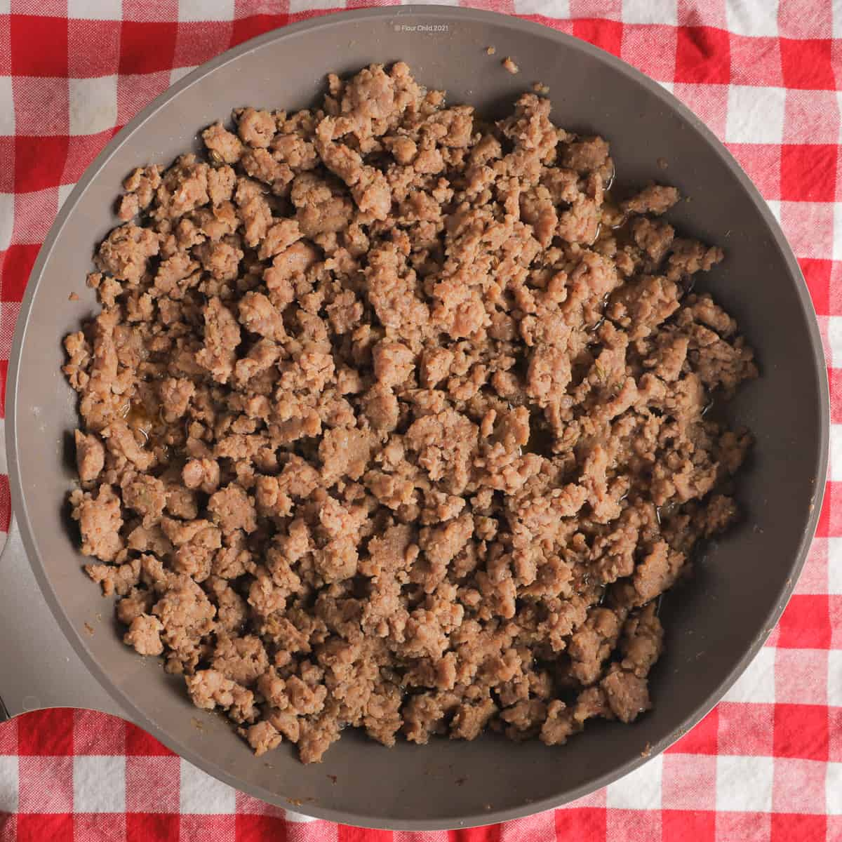 Italian sausage browning in a large skillet