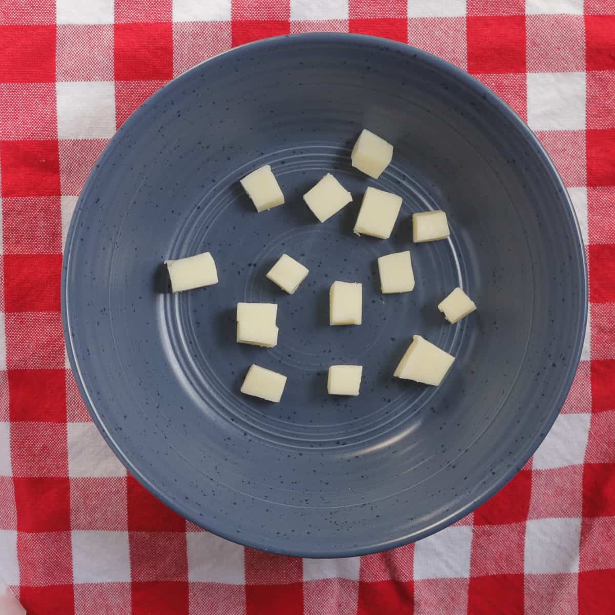 Cubed mozzarella in bottom of serving bowl