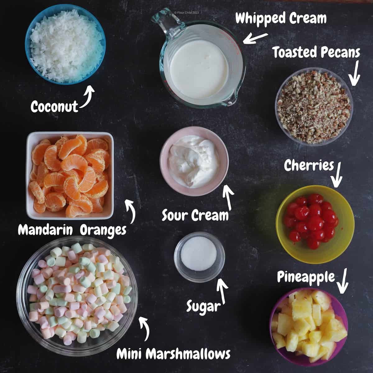 All ingredients for ambrosia salad laid out on a board.