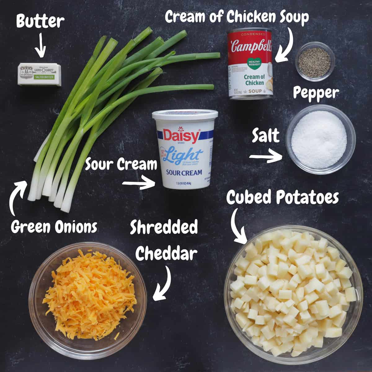 All ingredients for cheesy potato casserole laid out on board