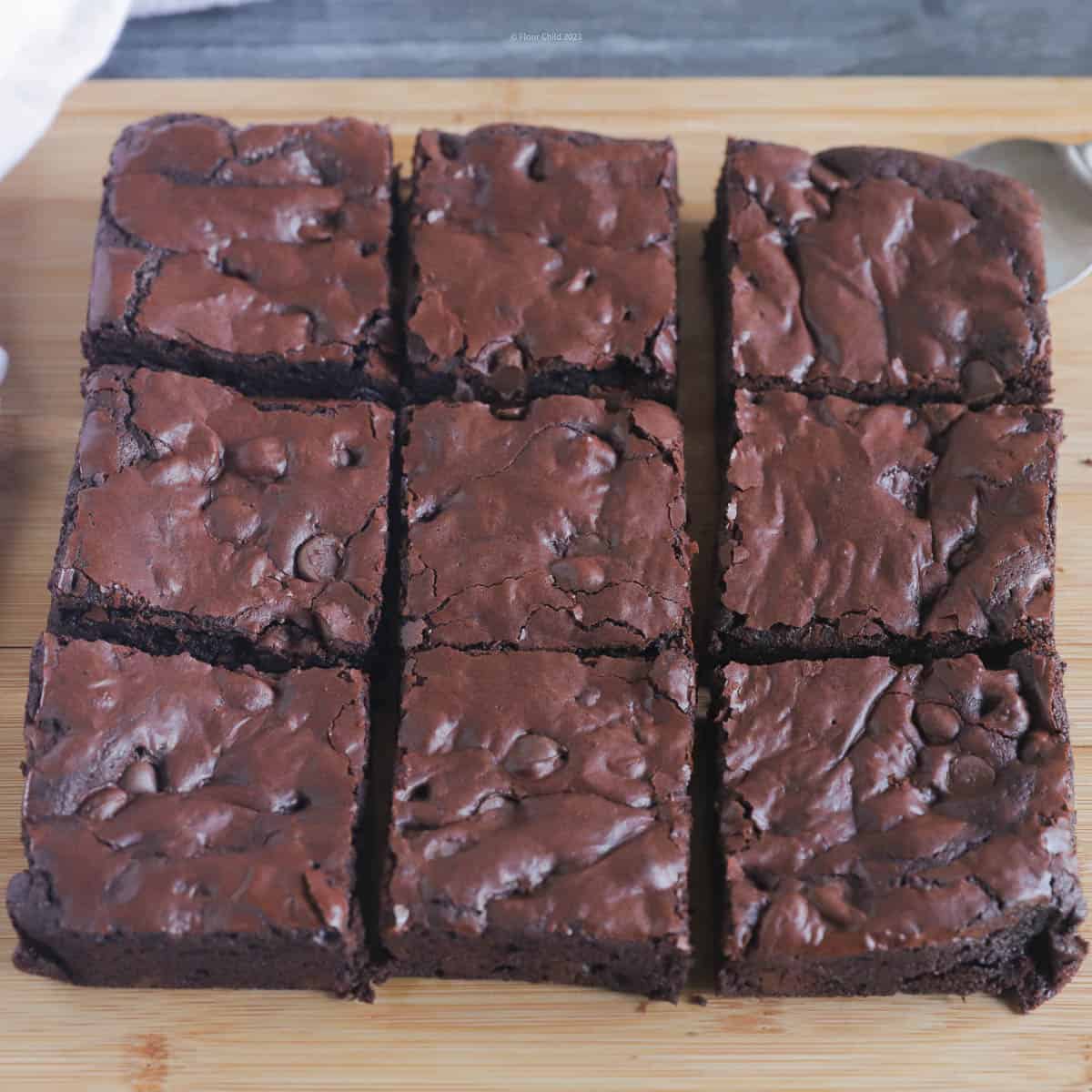 Brownies on a cutting board, cut into 9 individual servings.