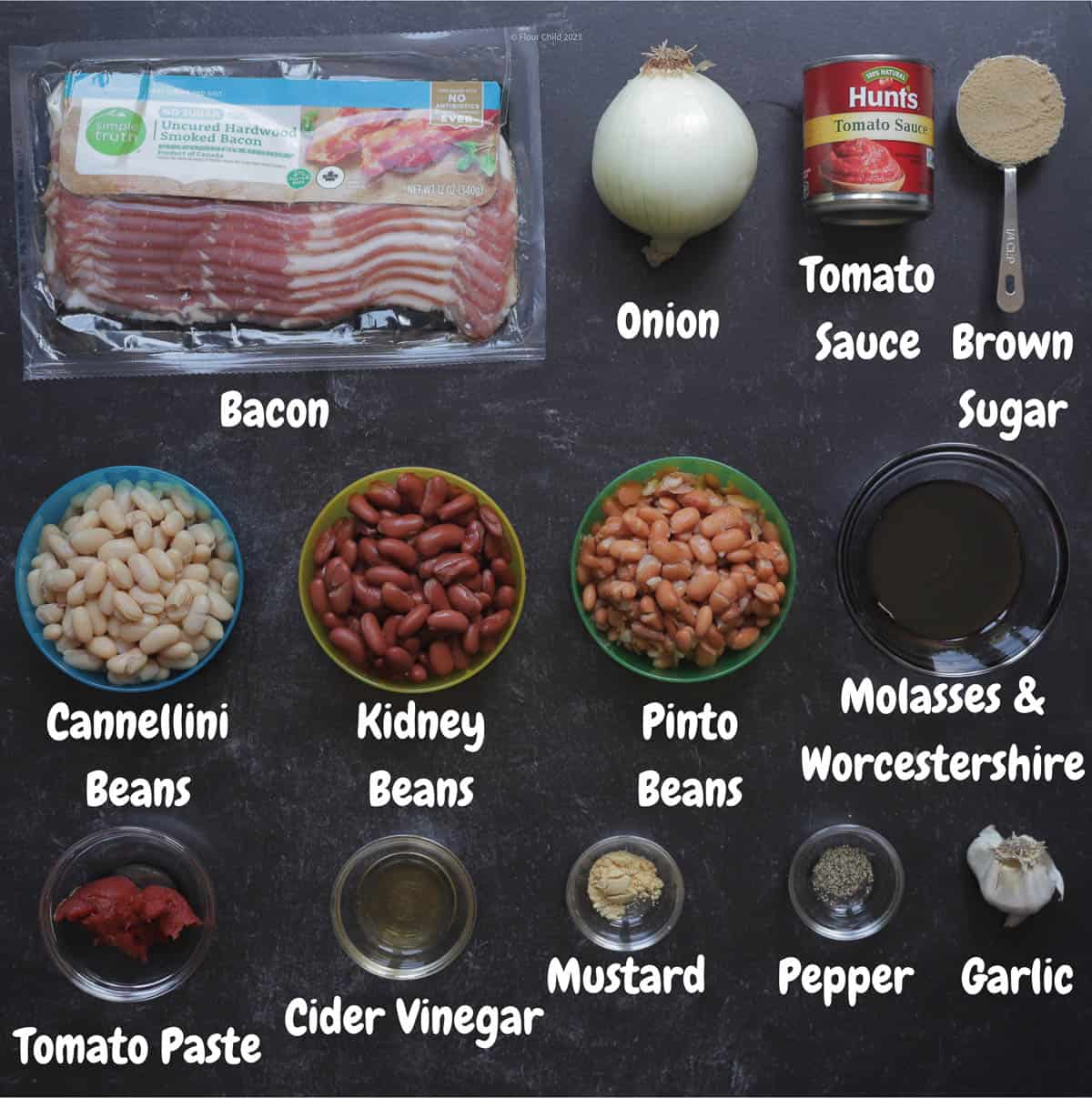 Ingredients for easy homemade barbecued beans laid out on a black background.