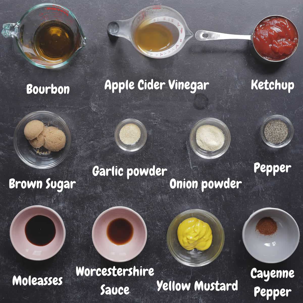 All of the ingredients for barbecue sauce set on a black background.