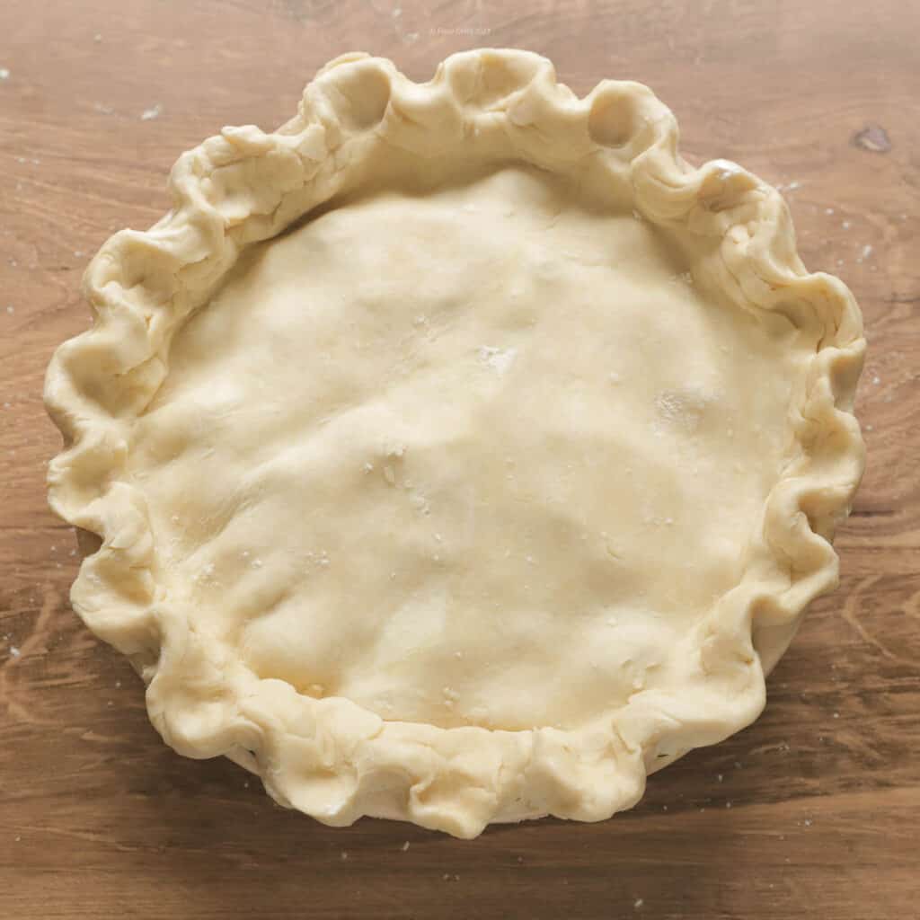 Pie with top and bottom pie crust in place and edge crimped.