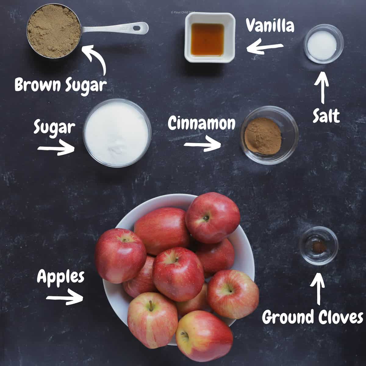 All of the ingredients needed to make apple butter on a black background.