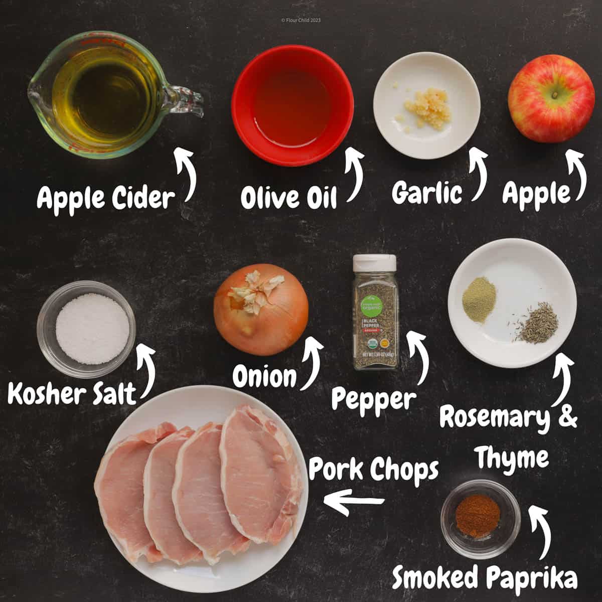 All the ingredients needed to make boneless apple cider pork chops, on a black background.