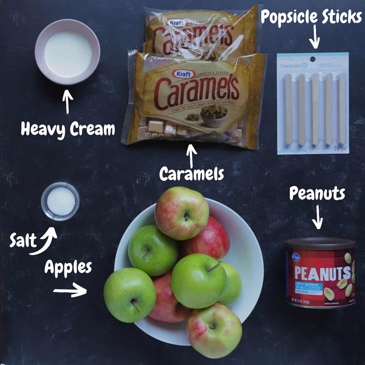 All of the ingredients to make taffy apples, on a black background.