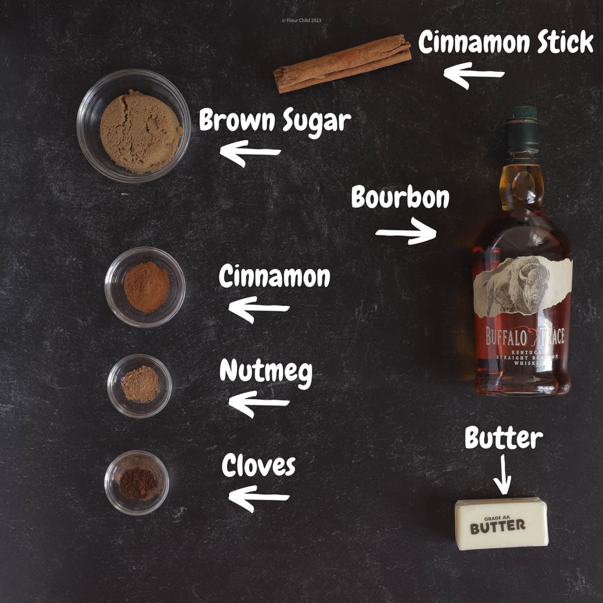 Ingredients needed for hot buttered bourbon, bottle of buffalo trace, butter, brown sugar, nutmeg, cloves and cinnamon and stick