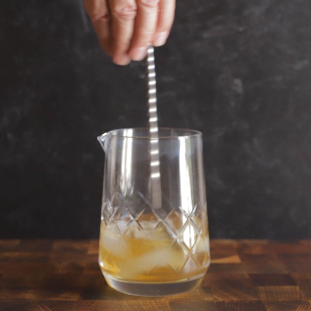 Three steps of pouring and stirring spirits for a rusty nail cocktail in a mixing glass.