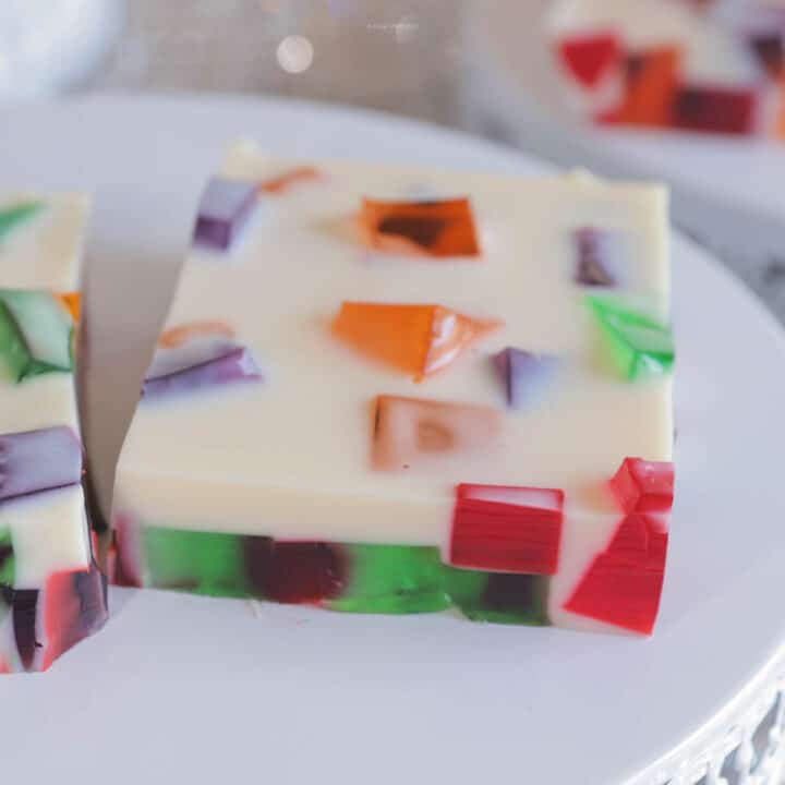 A single square serving of stained glass jello on a white plate.