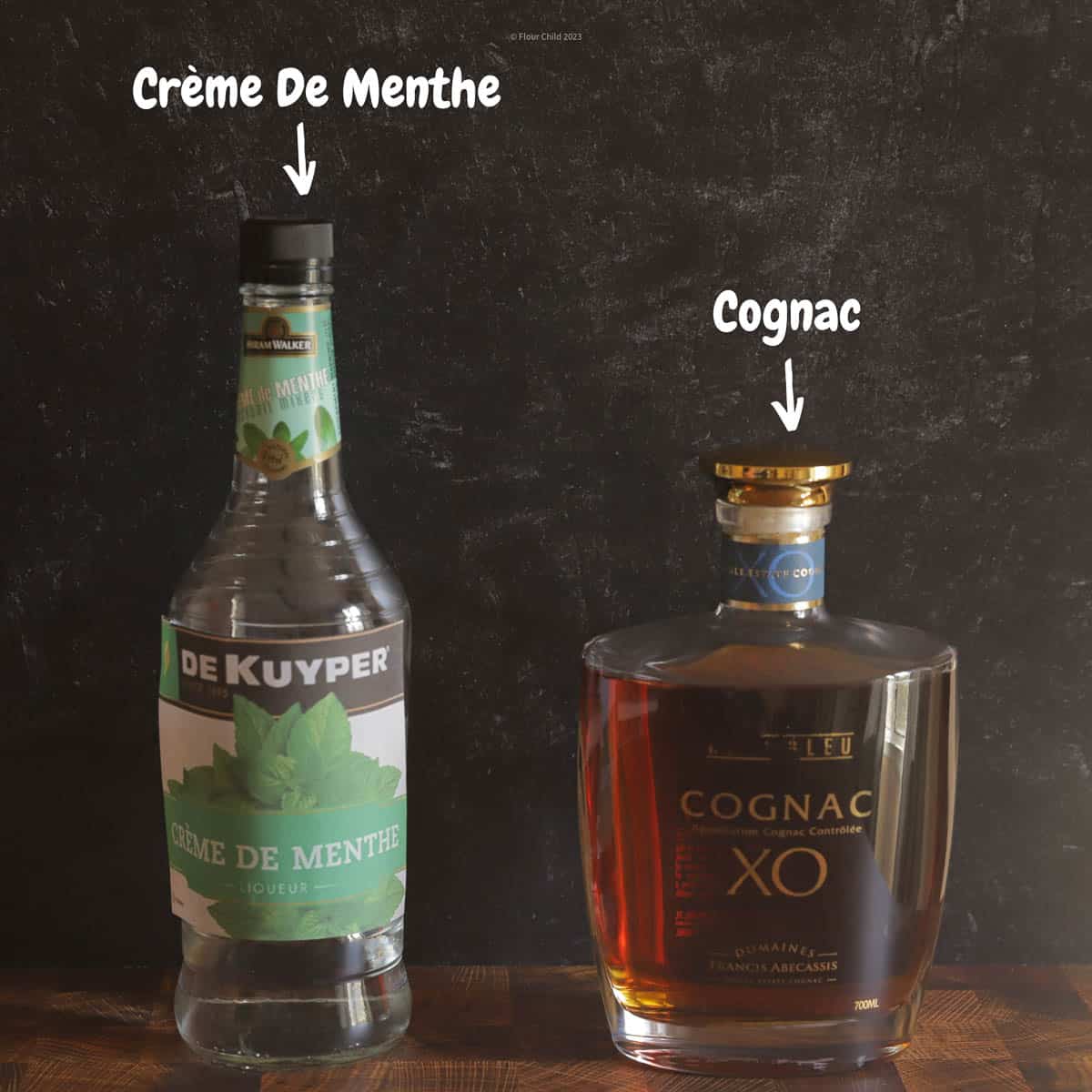 Bottle of Cognac and Creme de Menthe on a black background