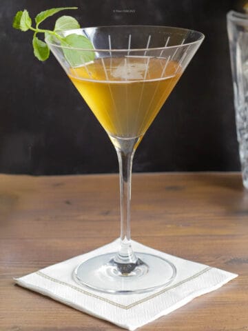 Stinger cocktail with a sprig of mint in a cocktail glass