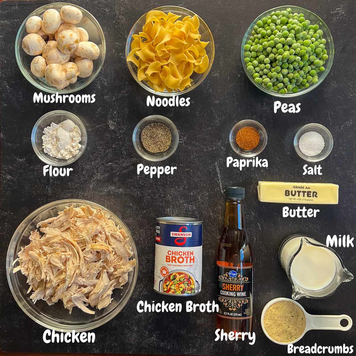 All of the chicken casserole ingredients laid out on a black background.