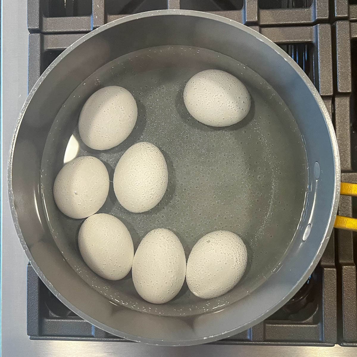 Eggs cooking in a pot on the stovetop.