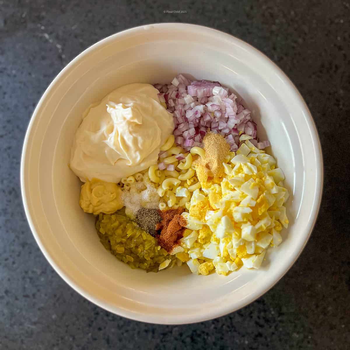 All ingredients for deviled eggs salad in a mixing bowl.