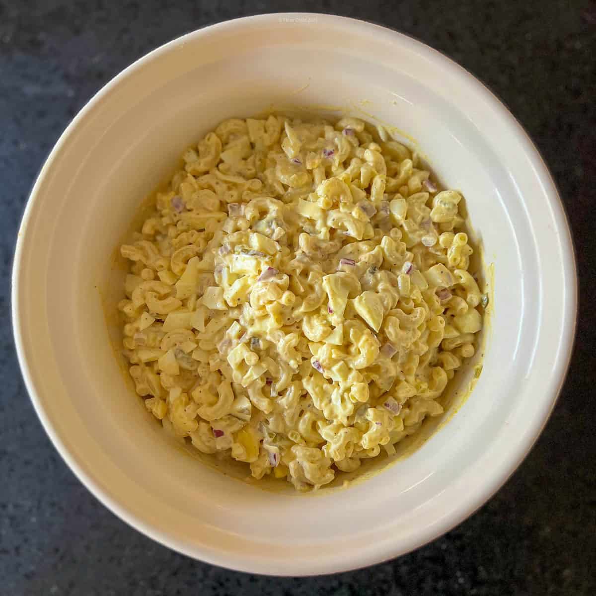 All ingredients for deviled egg salad mixed together in a mixing bowl and ready to chill.
